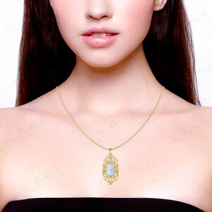 May include: A gold chain necklace with a pendant featuring a light blue gemstone set in a gold filigree frame.