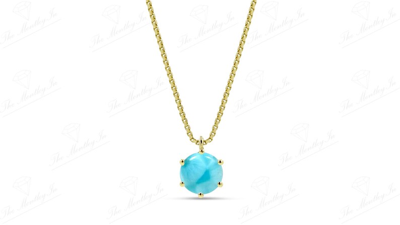 Op de afbeelding: Een gouden ketting met een hanger van lichtblauwe edelsteen. De hanger is rond en heeft een facetgeslepen ontwerp.
