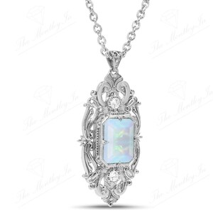 May include: A silver pendant necklace with a white opal gemstone set in a detailed filigree design.