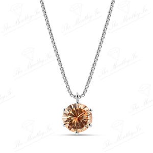 May include: A silver necklace with a round, light brown gemstone pendant. The pendant is set in a silver bezel and hangs from a delicate silver chain. The gemstone has multiple facets.