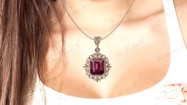 May include: A silver chain necklace with a pendant featuring a large, dark purple, emerald-cut gemstone set in a silver filigree frame.