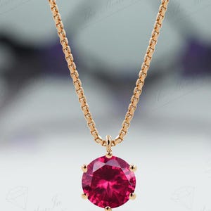 以下が含まれることがあります： ローズゴールドのチェーンネックレスに、丸い鮮やかなピンクの宝石のペンダントが付いている。