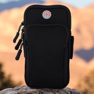 May include: Black phone armband with a zipper closure and a small orange logo. The armband has a strap to secure it to your arm.