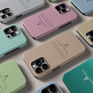 May include: A set of phone cases with a western theme. The cases feature a skull with horns and a quote about not fearing anything. The cases are available in a variety of colours, including pink, green, blue, and brown.