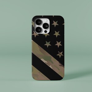 May include: A black phone case with a camouflage pattern and a US flag design. The case has a raised camera bump with three lenses.