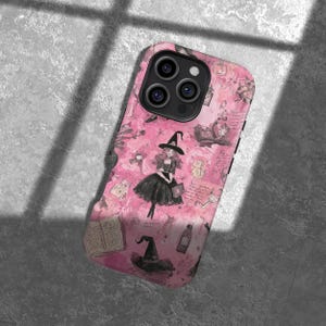 Op de afbeelding: Roze telefoonhoesje met een heksen-thema ontwerp. De hoes heeft een heksenillustratie, heksenhoeden, boeken en andere Halloween-gerelateerde afbeeldingen. De hoes heeft een glanzende afwerking en is ontworpen voor een smartphone.