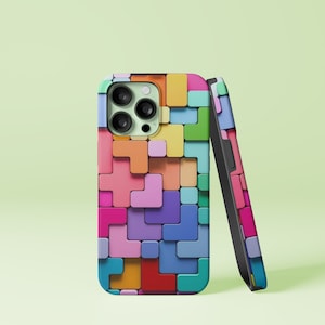 Op de afbeelding: Een kleurrijke telefoonhoes met een Tetris-achtig patroon van verschillende gekleurde blokken. De hoes is ontworpen voor een telefoon met een drievoudige camera lens.