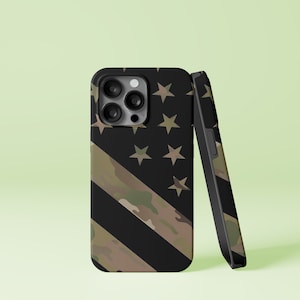 May include: A black phone case with a camouflage pattern and an American flag design. The case has a cutout for the phone's camera.