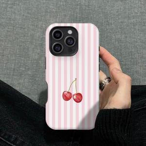 Op de afbeelding: Telefoonhoesje met roze en witte strepen, versierd met een aquarel illustratie van twee rode kersen. De hoes heeft een glanzende afwerking en een camera-uitsparing.