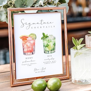 May include: A rose gold framed sign with the words "Signature Cocktails" and illustrations of two cocktails. The sign is next to three glasses of cocktails garnished with lime and mint. Two limes sit in front of the sign.