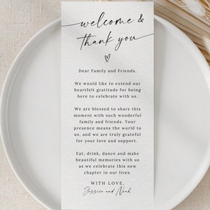 May include: A rectangular card with the text "welcome & thank you" in elegant script, along with a heartfelt message. The card is placed on a white plate, suitable for a wedding or special event.