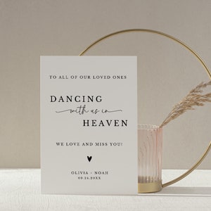 May include: A white card with black text that reads "To all of our loved ones, Dancing with us in Heaven, We love and miss you! Olivia - Noah 09.24.20XX".