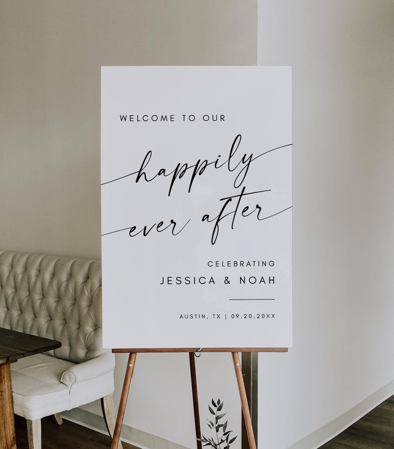 May include: A white wedding sign on a wooden easel. The sign reads "WELCOME TO OUR happily ever after CELEBRATING JESSICA & NOAH AUSTIN, TX | 09.20.20XX" in black script and block lettering. The sign is displayed indoors.