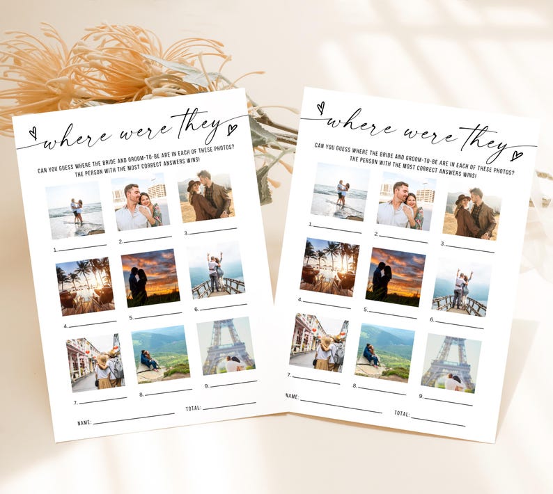 May include: Two white paper game sheets with the text "where were they" and a series of photos. The game asks players to guess the location of the bride and groom in each photo. The sheets are decorated with small heart shapes.