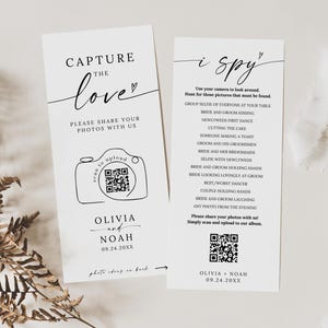 May include: Two white wedding signs with black text. One says "Capture the love" with a camera graphic and QR code. The other says "i spy" with a list of photo prompts and a QR code. Names and a date are at the bottom.