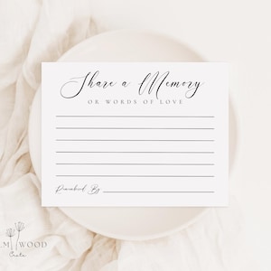May include: A white rectangular card with black text that reads Share a Memory OR WORDS OF LOVE, followed by seven horizontal lines for writing and a final line labeled Remembered By. The card features elegant script and serif typography.