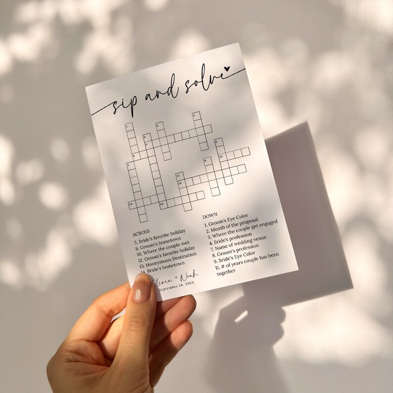 K&ouml;nnte beinhalten: Ein schwarz-wei&szlig;es druckbares Hochzeits-Kreuzwortr&auml;tsel mit dem Text "sip and solve" oben. Das Kreuzwortr&auml;tsel hat 14 Hinweise quer und 11 Hinweise runter. Die Hinweise beziehen sich auf die pers&ouml;nlichen Informationen der Braut und des Br&auml;utigams, wie z. B. ihren Lieblingsfeiertag, ihre Heimatstadt und wo sie sich kennengelernt haben. Das Kreuzwortr&auml;tsel ist f&uuml;r einen Hochzeitsempfang oder eine Brautparty gedacht.