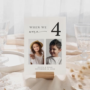May include: A cream-colored photo card with the text "WHEN WE were 4" and two photos of children. The card includes the names Olivia & Noah and the date September 12, 20XX. The card is held by a small wooden block.