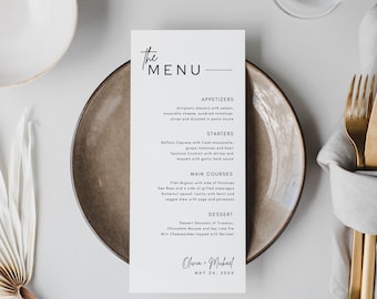 May include: A vertical menu card with the text "the MENU" in black, listing appetizers, starters, main courses, and dessert options. The card is on a brown plate, with gold silverware and a white napkin to the right. The menu is signed "Olivia + Michael" with the date "MAY 24, 20XX".