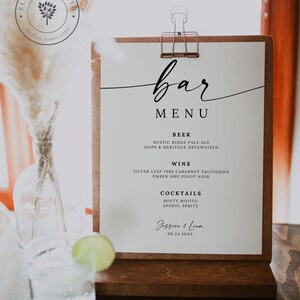 Może przedstawiać: Drewniany szyld z menu barowym z białym tłem i czarnym napisem "bar MENU". Menu zawiera piwo, wino i koktajle. Znak jest trzymany przez miedziany klips i stoi na drewnianej podstawie.