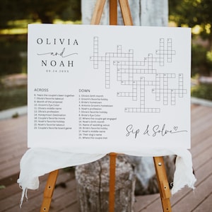 May include: A white sign on a wooden easel with a crossword puzzle and the names "Olivia and Noah" above. The date "09.24.20XX" is below the names. The words "Sip & Solve" are written in script.