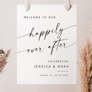 May include: A white wedding welcome sign with the words "WELCOME TO OUR" at the top. The phrase "happily ever after" is written in elegant script. The sign also includes the names "JESSICA & NOAH" and the city and date.