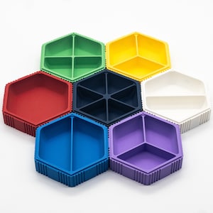 May include: Six hexagonal silicone containers in different colors: red, green, blue, purple, yellow, and black. Each container has multiple compartments.