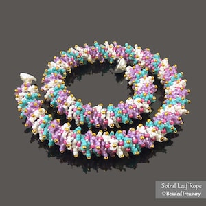 Peut inclure: Un collier de perles en forme de spirale. Il présente un mélange de perles blanches, turquoise, violettes et roses avec des accents dorés. Il possède un fermoir argenté. Le texte "Spiral Leaf Rope" et "©BeadedTreasury" est visible.