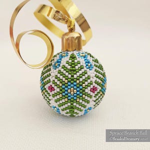 May include: A beaded Christmas bauble with a gold cap and ribbon. The bauble features a pattern of spruce branches in white, green, blue, and gold. Text reads "Spruce Branch Ball" and "Beaded Treasury 2020".