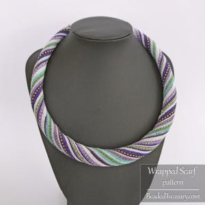 Peut inclure: Un collier de perles aux tons violets, blancs, verts et turquoise, présenté sur un mannequin noir. Le collier présente un motif en spirale. L'image comprend le texte "Wrapped Scarf pattern" et "Beaded Treasury."