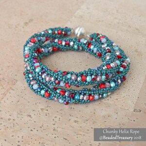 Puede incluir: Una pulsera de cuentas con un diseño de cuerda de hélice gruesa. La pulsera presenta cuentas de color turquesa, rojo e iridiscente. La pulsera está hecha de múltiples hebras y tiene un cierre plateado. El texto "Chunky Helix Rope @BeadedTreasury 2018" está en la imagen.