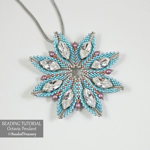 Puede incluir: Un collar con colgante de cuentas con un diseño de copo de nieve. El colgante presenta un patrón de cuentas azul claro y plateado con detalles de cristal transparente y pequeñas cuentas moradas. El collar tiene una cadena plateada. El texto en la imagen dice "BEADING TUTORIAL Octavia Pendant ©BeadedTreasury."