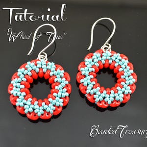 May include: A pair of handmade earrings with a circular design. The earrings feature a combination of red and light blue beads, arranged in a repeating pattern. The text "Tutorial Wheel of Time" is visible at the top of the image.