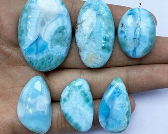 Peut inclure: Six pierres précieuses en cabochon, chacune avec un motif unique de bleu, blanc et vert. Les pierres sont numérotées de 1 à 6.