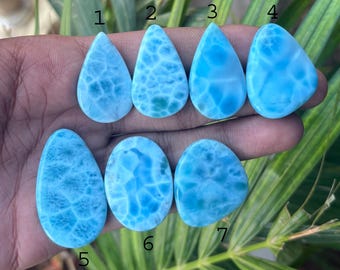 Può includere: Una collezione di sette pietre preziose di larimar lucidate in varie forme. Le pietre variano dal blu chiaro al medio, con venature bianche e blu scuro. Le pietre preziose hanno forme a goccia, ovali e irregolari.