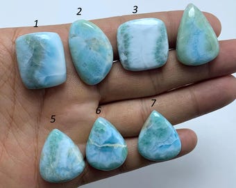 Peut inclure: Sept pierres précieuses polies en cabochon de différentes formes et tailles. Les pierres sont de couleur bleu clair avec des inclusions blanches et vertes. Les pierres sont numérotées de 1 à 7.