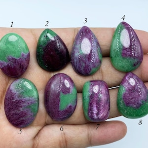 Peut inclure: Huit cabochons de pierres précieuses vertes et violettes de différentes formes, notamment ovales et en forme de larme. Les pierres sont numérotées de 1 à 8.