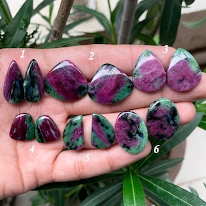 May include: Six pairs of green and pink gemstone cabochons, numbered 1 through 6. The cabochons are various shapes and sizes, including teardrop, oval, and triangular.