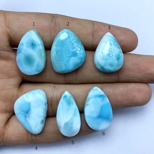 May include: Six teardrop-shaped cabochons of blue and white  cabochon gemstones. The stones are arranged in two rows of three. The stones are labeled 1 through 6.