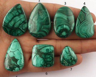 Pode incluir: Sete cabochões de malaquita verde em várias formas, incluindo gota, oval e quadrado, com padrões intrincados de veios verdes e pretos que se entrelaçam. Os cabochões são numerados de 1 a 7.