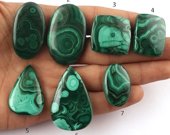 Pode incluir: Sete cabochões de malaquita verde de vários formatos e tamanhos, numerados de 1 a 7.