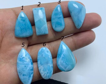 Peut inclure: Dix pierres précieuses en cabochon de différentes formes et tailles, allant de la goutte d'eau à l'ovale, avec un motif marbré bleu clair et blanc. Les pierres sont numérotées de 1 à 7.