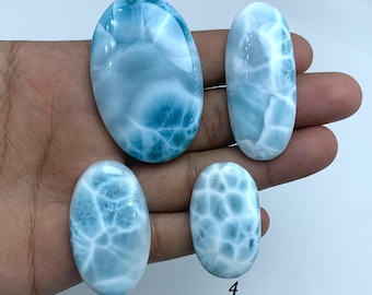 Op de afbeelding: Vier ovale, blauwe en witte edelsteen cabochons, genummerd van 1 tot en met 4.