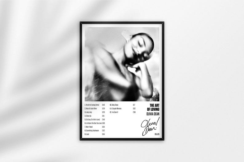 May include: Monochrome framed poster with a blurred image of a person. The poster displays the text "THE ART OF LOVING" and the artist's name, Olivia Dean, alongside a list of song titles and timings.
