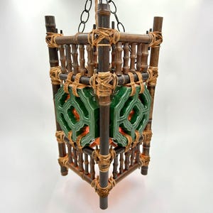 May include: A square bamboo pendant light with green and brown ceramic tiles. The light is suspended from a chain and has a rustic, natural look.