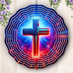 May include: A metal wind spinner with a red, white, and blue American flag cross design. The cross is surrounded by a blue and red background with white stars. The wind spinner is circular and has a scalloped edge.