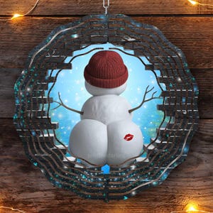 K&ouml;nnte beinhalten: Ein Schneemann mit rotem Hut, der durch eine Ziegelmauer mit blauem und wei&szlig;em Hintergrund lugt. Der Schneemann hat ein rotes Herz auf seinem R&uuml;cken.