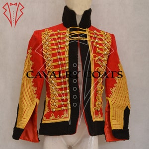 May include: A red military-style jacket with gold trim and buttons. The jacket has a black fur collar and is lined with black fabric. The text "CAVALRY COATS" is visible on the front of the jacket.