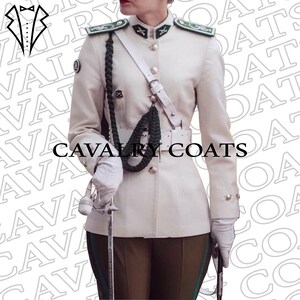 May include: A white military jacket with green trim and a black braided cord. The jacket has a white belt and a white strap across the chest. The text "CAVALRY COATS" is printed on the jacket.
