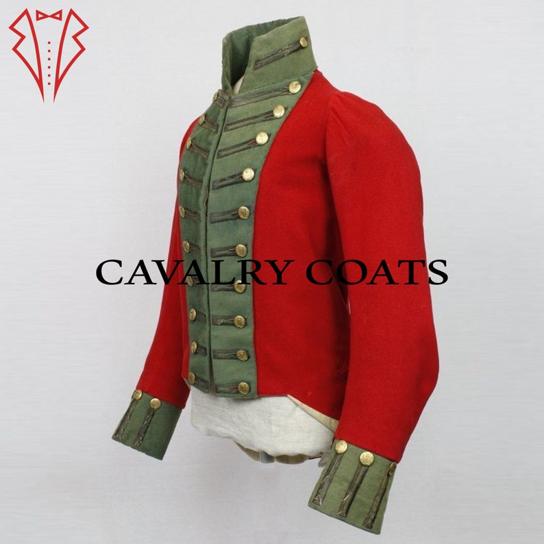 K&ouml;nnte beinhalten: Eine rote Milit&auml;rjacke mit gr&uuml;nem Besatz und goldenen Kn&ouml;pfen. Die Jacke hat einen hohen Kragen und lange &Auml;rmel. Der Text "CAVALRY COATS" ist auf der Vorderseite der Jacke aufgedruckt.